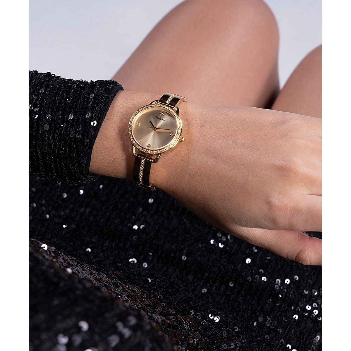 GUESS Mod. BELLINI lady's wristwatch with gold SS IP strap, 30mm case, quartz movement, displayed on a sequined fabric sleeve, 3 ATM water resistant.