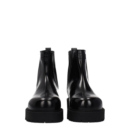 Front view of Givenchy Black Leather Ankle Boots with rubber sole and round toe design, showcasing front and back logos for a casual style.