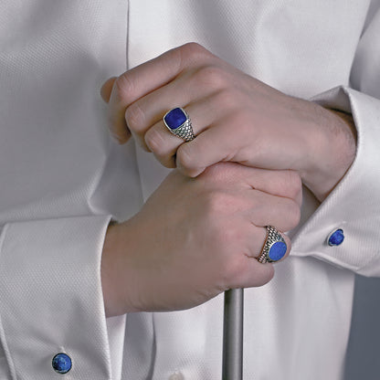 Close-up of hands wearing ALBERT M. JEWELS JEWELRY Mod. WSOX00174.TRQ rings and cufflinks on a white shirt.