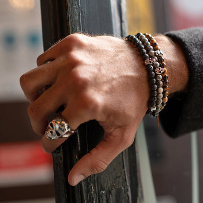 Man's hand wearing AN JEWELS JEWELRY Mod. AA.P255RBR bracelet and skull ring, stylish and modern fashion accessory.