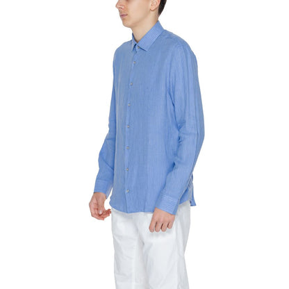 Man wearing Calvin Klein Blue Linen Dress Shirt with long sleeves and button closure.