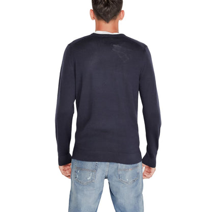 Back view of a man wearing a Calvin Klein Blue Recycled Wool Sweatshirt with denim jeans, showcasing a stylish and sustainable fashion choice.