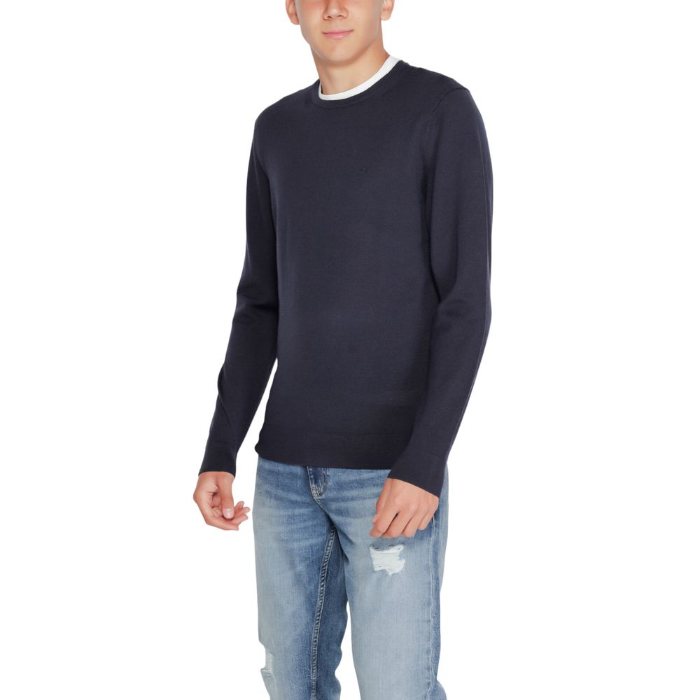 Calvin Klein Blue Recycled Wool Sweatshirt on model, featuring crew neck and ribbed finish, emphasizing modern style and sustainability.
