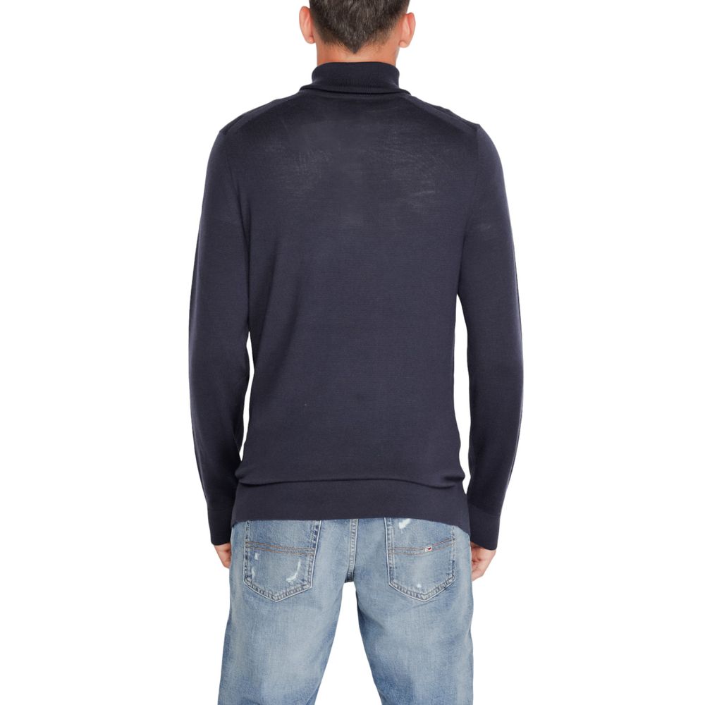 Back view of Calvin Klein Blue Wool Turtleneck on model, showcasing elegant and comfortable fit for men's winter wardrobe.