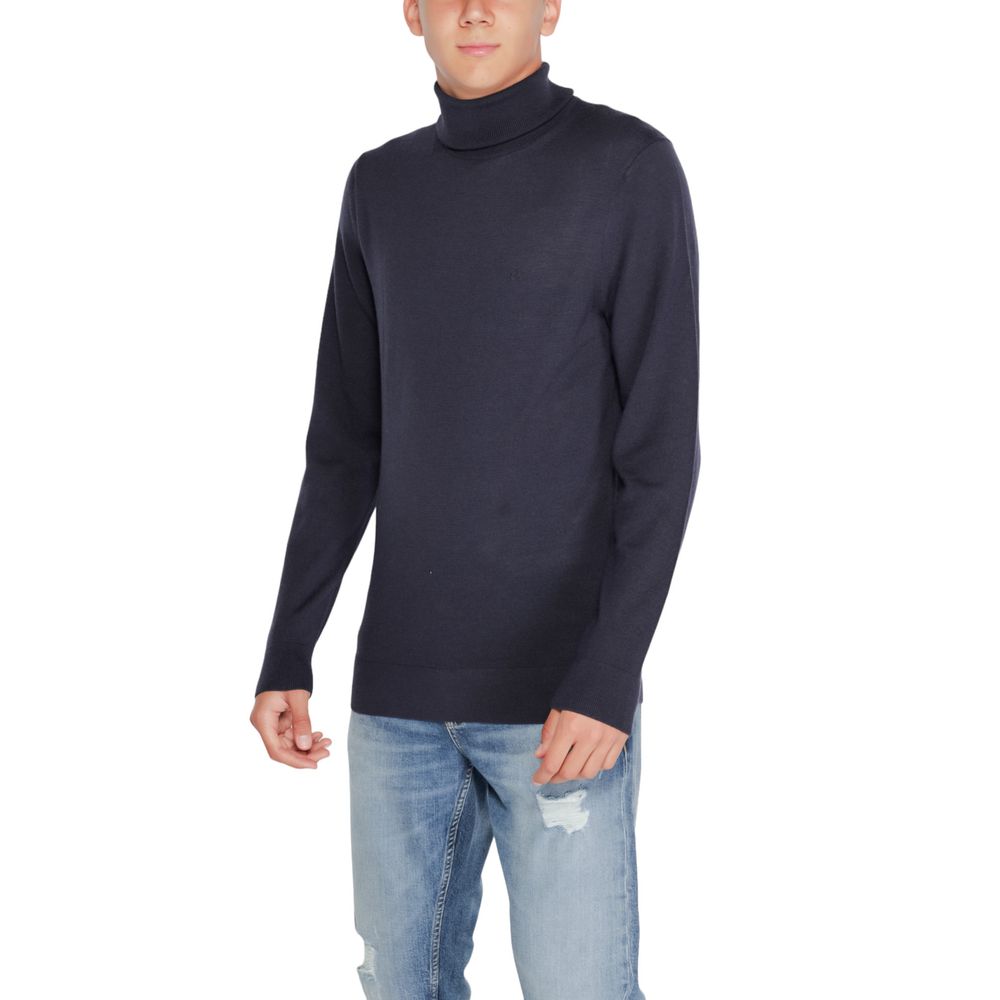 Model wearing Calvin Klein Blue Wool Turtleneck, a stylish and comfortable winter sweater made from RWS Merino wool, perfect for any occasion.