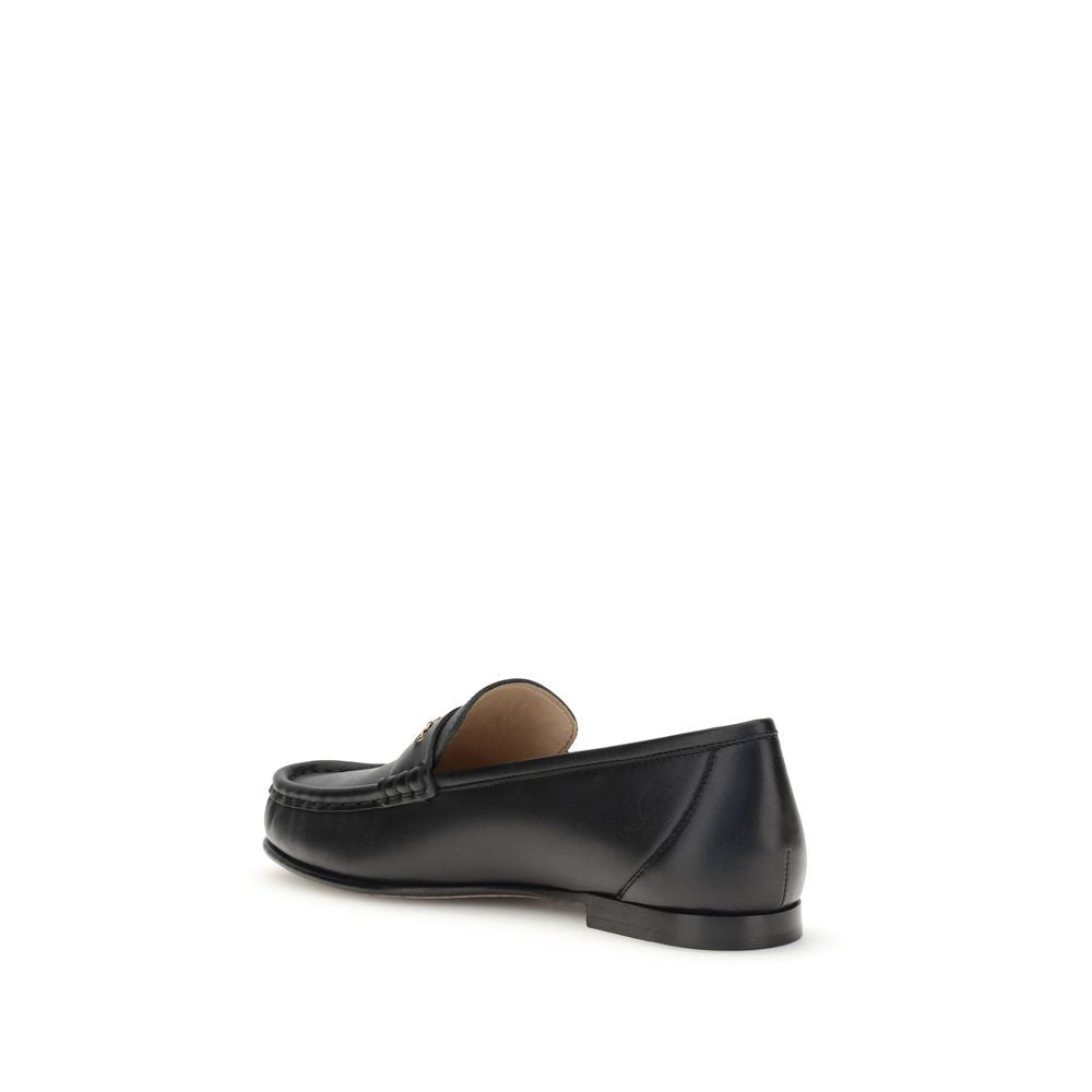 Chloé Black Calf Leather Bos Taurus Slip-On Loafers with gold chain detail, back view showcasing elegant silhouette and fine craftsmanship.