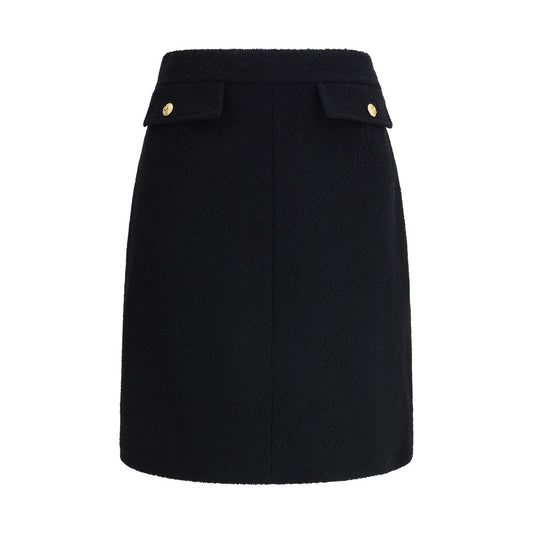 Chloé Black Wool Midi Skirt with bouclé texture and gold-tone buttons, features front flap pockets and side zip for a sleek fit.