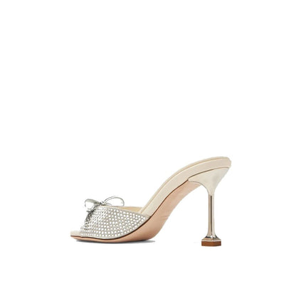 Miu Miu Silver Silk Mules with crystal embellishment, open toe design, and top bow detail. Elegant high heel, slip-on style for women.