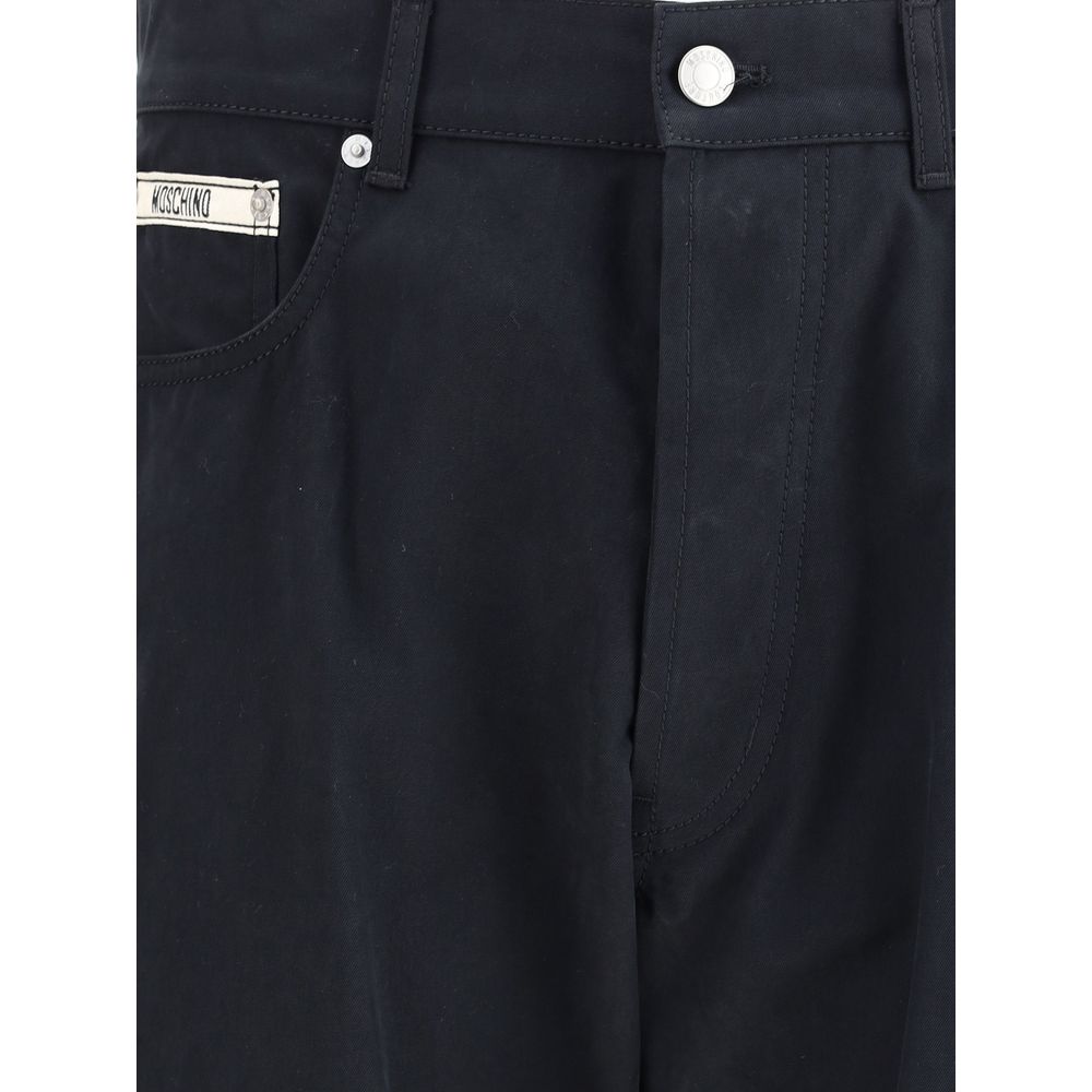Close-up of Moschino Black Cotton Casual Pants with signature front patch and straight-leg cut, featuring button and zip closure.