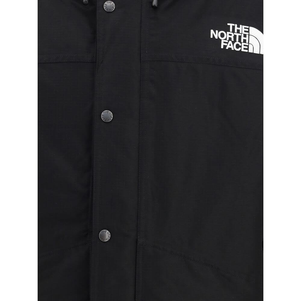 Close-up of The North Face Black Polyester Coat showcasing button detail and logo on chest.