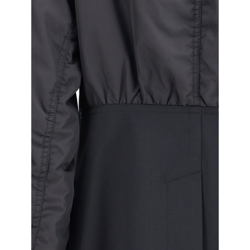 Close-up of Undercover Black Polyester Bomber with shawl lapel, zippered sleeve pocket, and ribbed cuffs, showing detailed design.